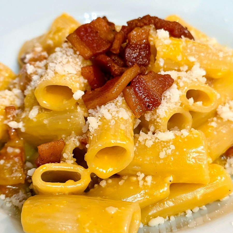 A plate of rigatoni carbonara with guanciale and pecorino