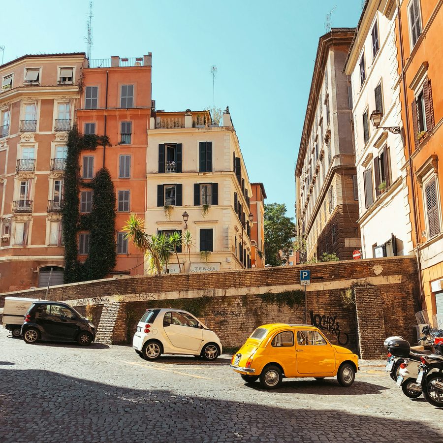 A quiet Italian street with parked Fiat 500s