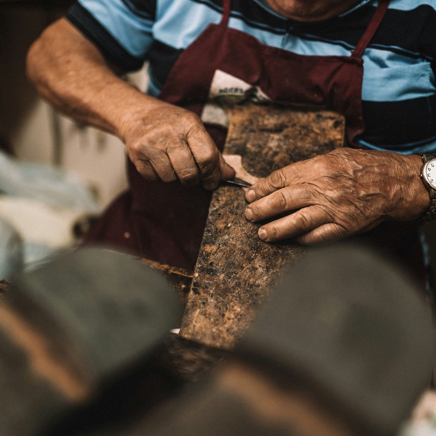 A craftsman shaping a piece of leather by hand