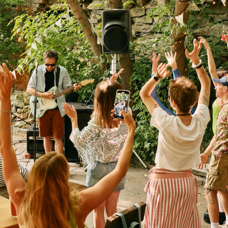 A crowd with raised hands at an open-air summer festival