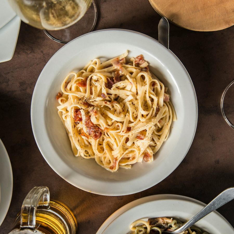 A shared table of pasta and wine