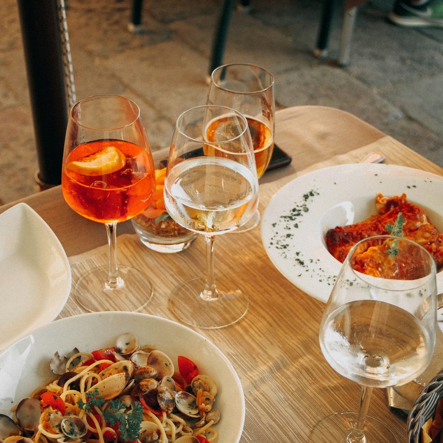A table with spritz, wine and pasta in Italy